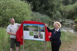Dr. Bernd Hoppe-Dominik (FUN e. V.) und Judith Kraft (Geschäftsführerin SEBS) enthüllen eine der neuen Tafeln am Lehrpfad bei Rühme.