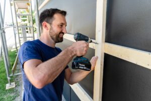 Handweker mit Akku-Schrauber: Die Holz-Unterkonstruktion wird mit Hinterlüftungsebene mit Trag- und Konterlattung montiert.