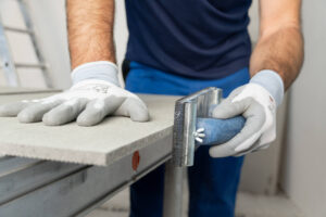 Die Kante der geschnittenen VeroBoard AllStar Platte wird mit dem Schleifgitter egalisiert.