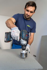 Handwerker schneidet Ausschnitte mit Bohraufsätzen aus der Leichtbauplatte