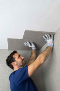 Handwerker belegt Nischen, Decken- und Wandanschlüsse mit der VeroBoard AllStar Keilplatte um Wärmebrücken zu verhindern.