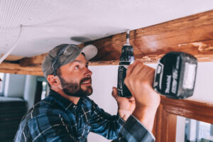 Handwerker mit Akku-Schrauber befestigt Leichtbauplatte an Innendecke. Die leichten VeroBoards sind auch für die Altbausanierung prädestiniert.