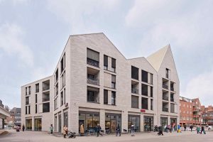 Gebäudeabbildung, Architekturforo: Die Satteldächer mit variierenden Firsthöhen unterstreichen den Eindruck eines aus mehreren Gebäuden gefügten Stadtblocks. Die zurückgesetzten Klinkerflächen sind um die Fenster und eingeschnittenen Loggien angeordnet.