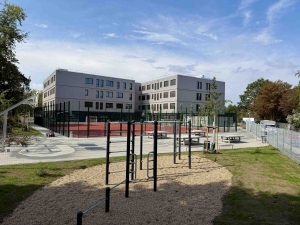 Vor dem Schulgebäude: Sportplatz, Pausenhof mit Tischtennis und Klettergerüst. - Zur neuen Schule gehört auch eine weitläufige Außenanlage