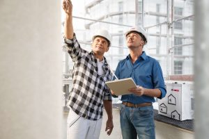 Zwei Männer auf Baustelle begutachten Fassade. Gemeinsam zum perfekten Ergebnis: Stimmen sich Systemgeber und Planer bzw. Bauunternehmen frühzeitig über die Baumaßnahme ab, passt die Lösung zum Problem – und die Dokumentation erfolgt gemäß neuer TR Instandhaltung.