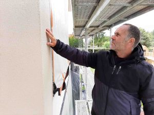 Handwerker auf Baustelle Fassadensanierung: Verarbeitungssicherheit bei nasskalter Witterung: Speziell eingestellte Fassaden-Beschichtungen lassen sich auch bei Temperaturen knapp über dem Gefrierpunkt noch sicher verarbeiten.