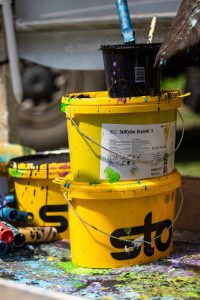 Farbeimer mit StoColor Dryonic: Als Projektpartner von STADT.WAND.KUNST unterstützt Sto die Wandkunst in Mannheim mit seinem langlebigen und farbintensiven Beschichtungssystem. Die Fassadenfarbe trägt dazu bei, dass die großflächigen Kunstwerke dauerhaft ihre Strahlkraft entfalten können.