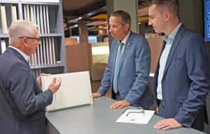 Drei Männer im Sto-Werk stehen um Tisch mit Produktmustern: (v.l.) Sto-Vorstandsvorsitzender Rainer Hüttenberger erläuterte Staatssekretär Thomas Dörflinger und Landtagsabgeordneten Simon Herzog die Produkte und Systeme von Sto.