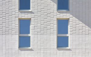 Außenaufnahme der Fassade mit Klinker des Sportlerhaus in HafenCity Hamburg. Die Fassade erzeugt durch die Neigungswechsel eine subtile Reflexion des Lichts ohne erkennbares Muster.