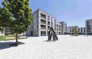 Gesamtaufnahme von Neubau in Blaustein mit Klinkerfassade. Moderne Stadtmitte in Blaustein: Das Gebäudeensemble vereint Wohnen mit Einkaufen und Arbeiten, die Tiefgarage bietet Platz für den ruhenden Verkehr. Rund 7.500 Quadratmeter Fläche – barrierefrei und energieeffizient.