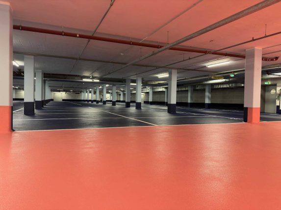 Tiefgarage der Kaufmännische Krankenkasse, Hannover. Schwarze Parkflächen und rote Bodenflächen