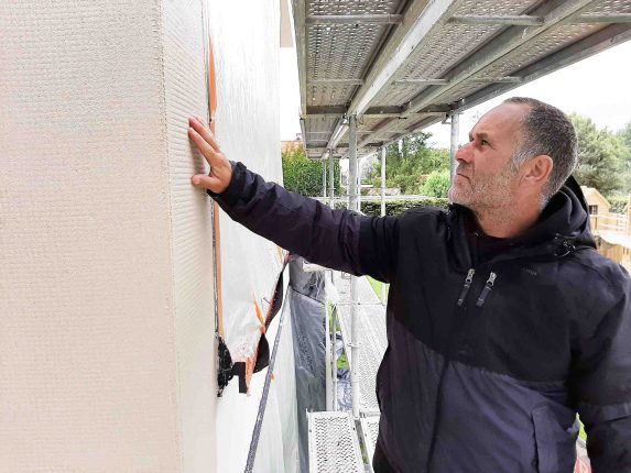 Handwerker auf Baustelle Fassadensanierung: Verarbeitungssicherheit bei nasskalter Witterung: Speziell eingestellte Fassaden-Beschichtungen lassen sich auch bei Temperaturen knapp über dem Gefrierpunkt noch sicher verarbeiten.