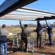 Vier Männer beim manuellen Einbau von Glasscheiben an einer Überdachung. - Auf Theorie folgt Praxis: Im Seminar „Montage“ legen die Teilnehmenden Hand an.